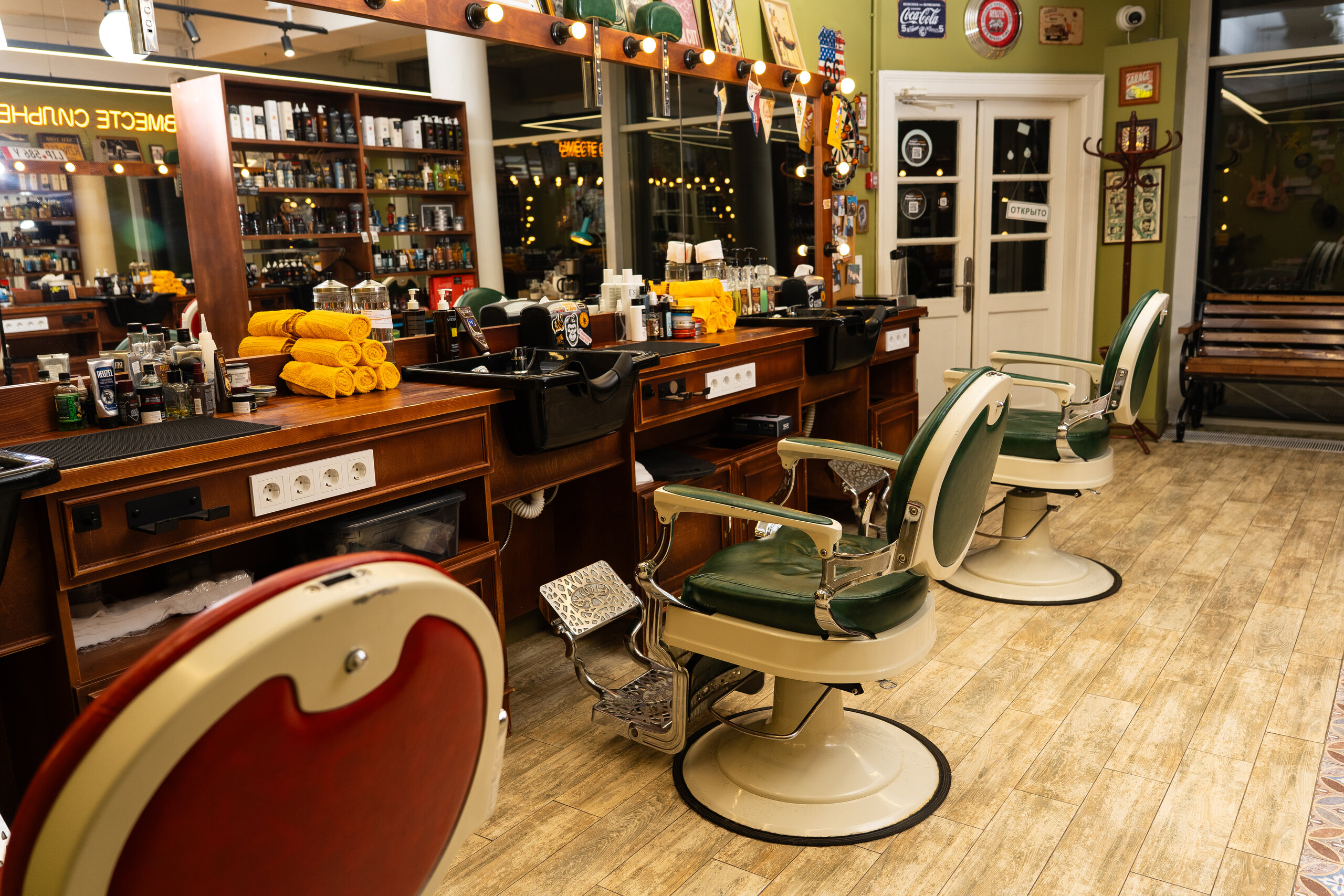 Интерьер барбершопа Fckng Barbers Бауманская с тремя креслами напротив большого окна и рабочей зоны с уходовыми средствами и инструментами