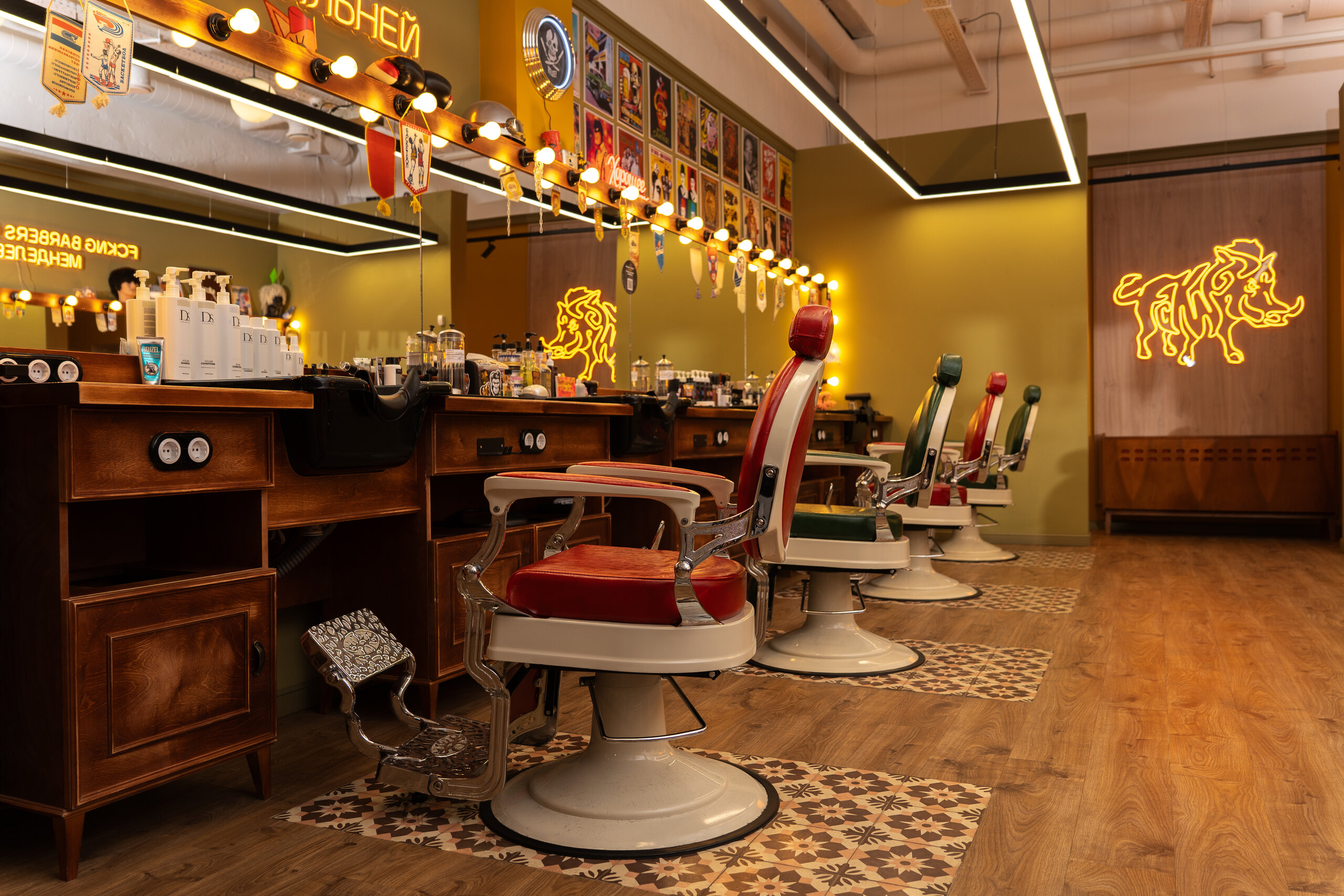 Интерьер барбершопа Fckng Barbers Менделеевская с 4 креслами напротив большого зеркала с подсветкой и неоновый логотип на входе